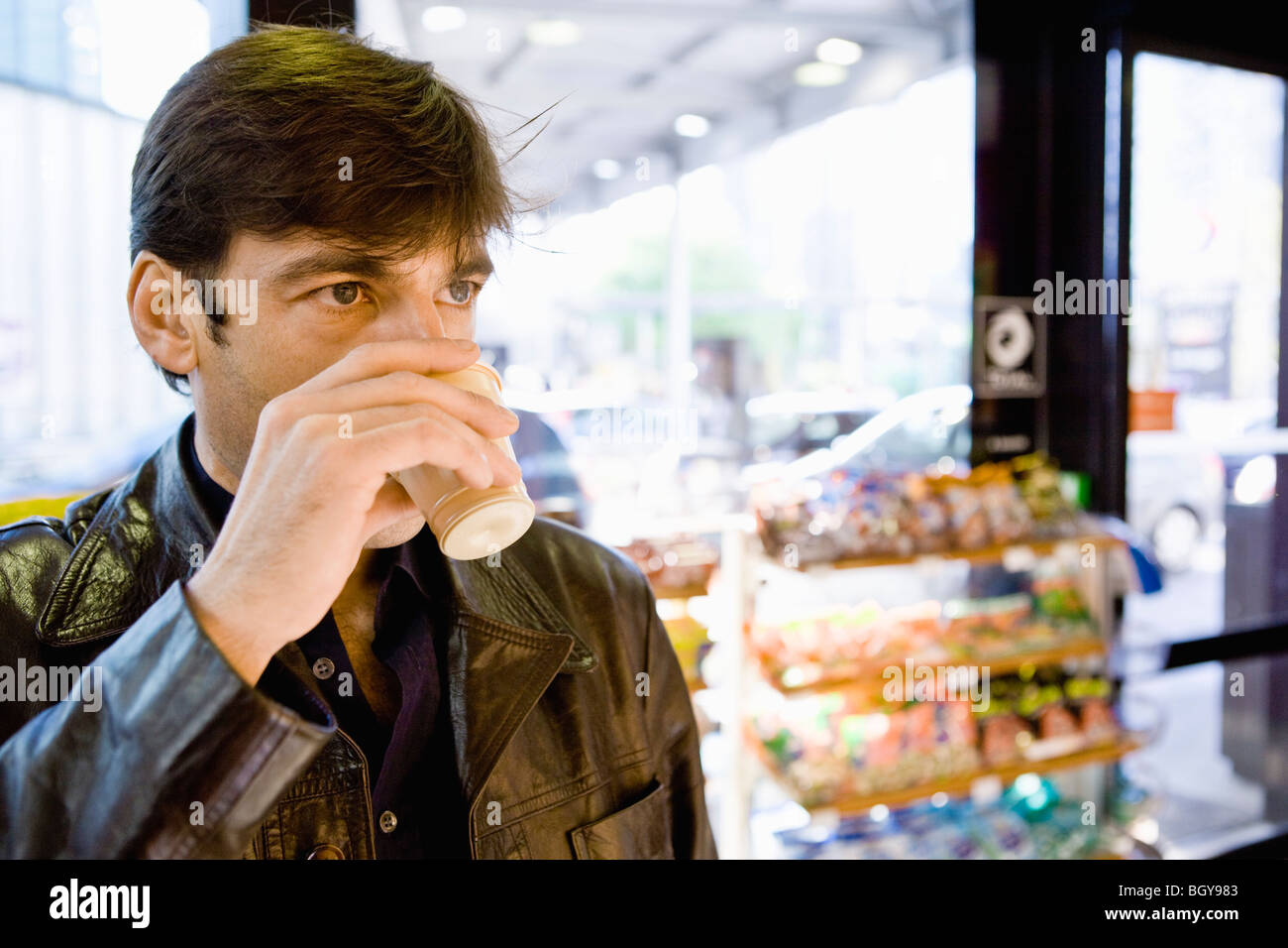 Man drinking coffee in convenience store Stock Photo Alamy