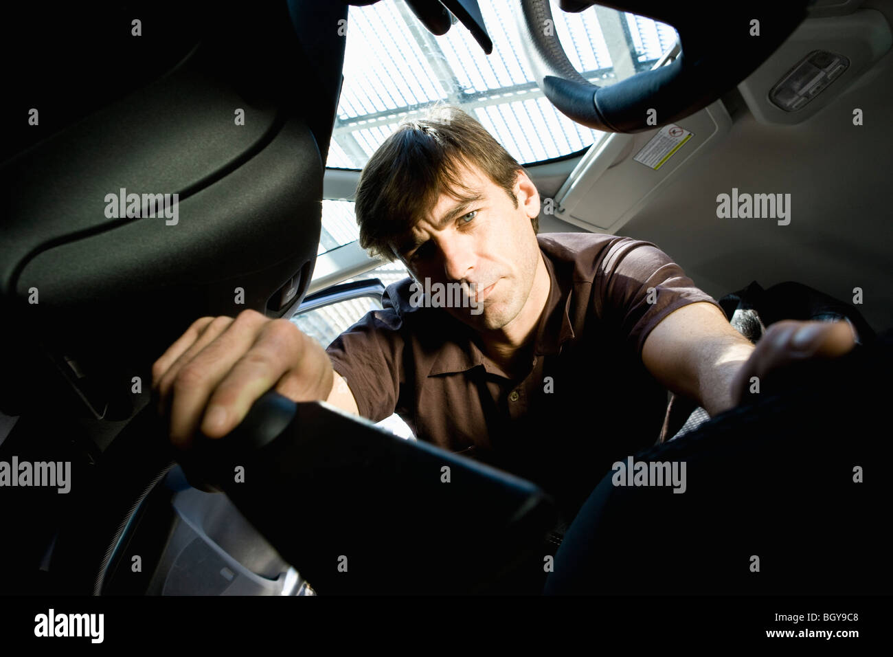 Man vacuuming interior of car Stock Photo