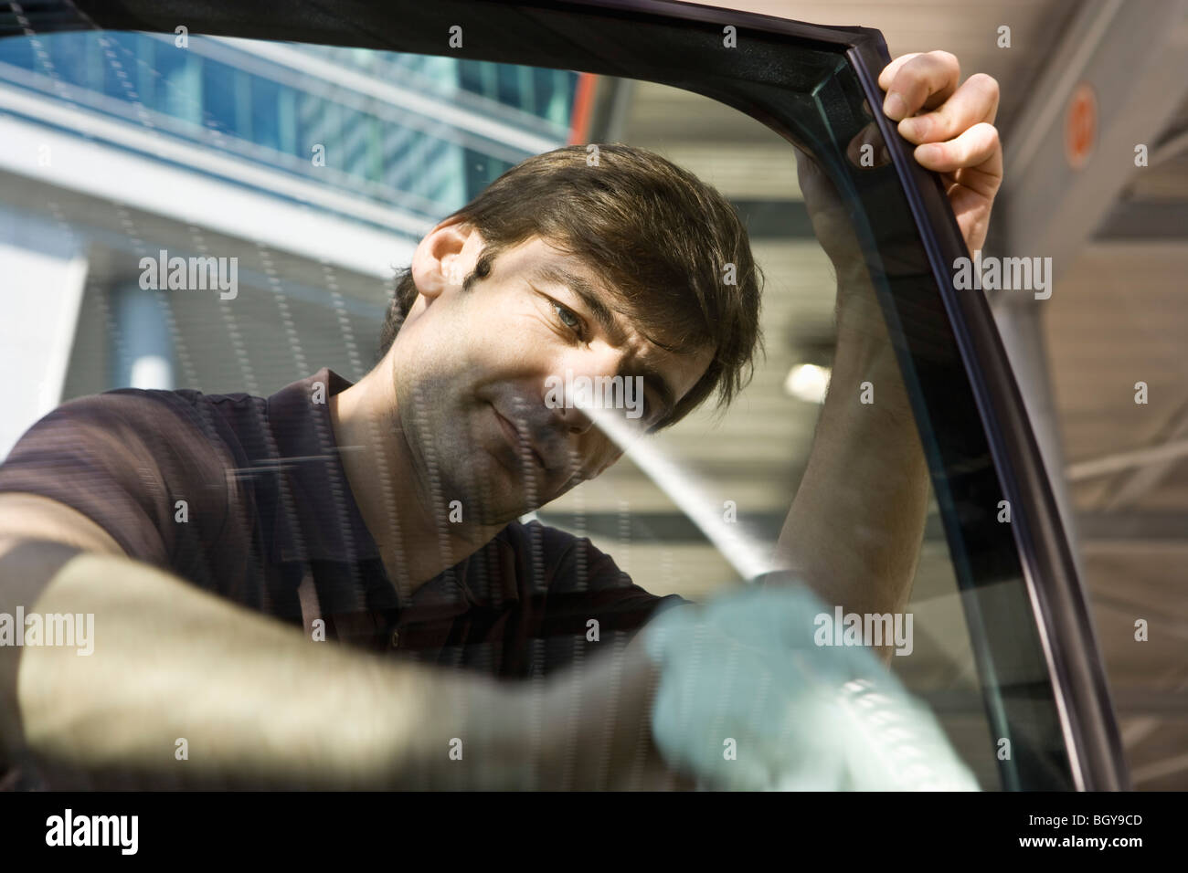 Man cleaning car door window Stock Photo