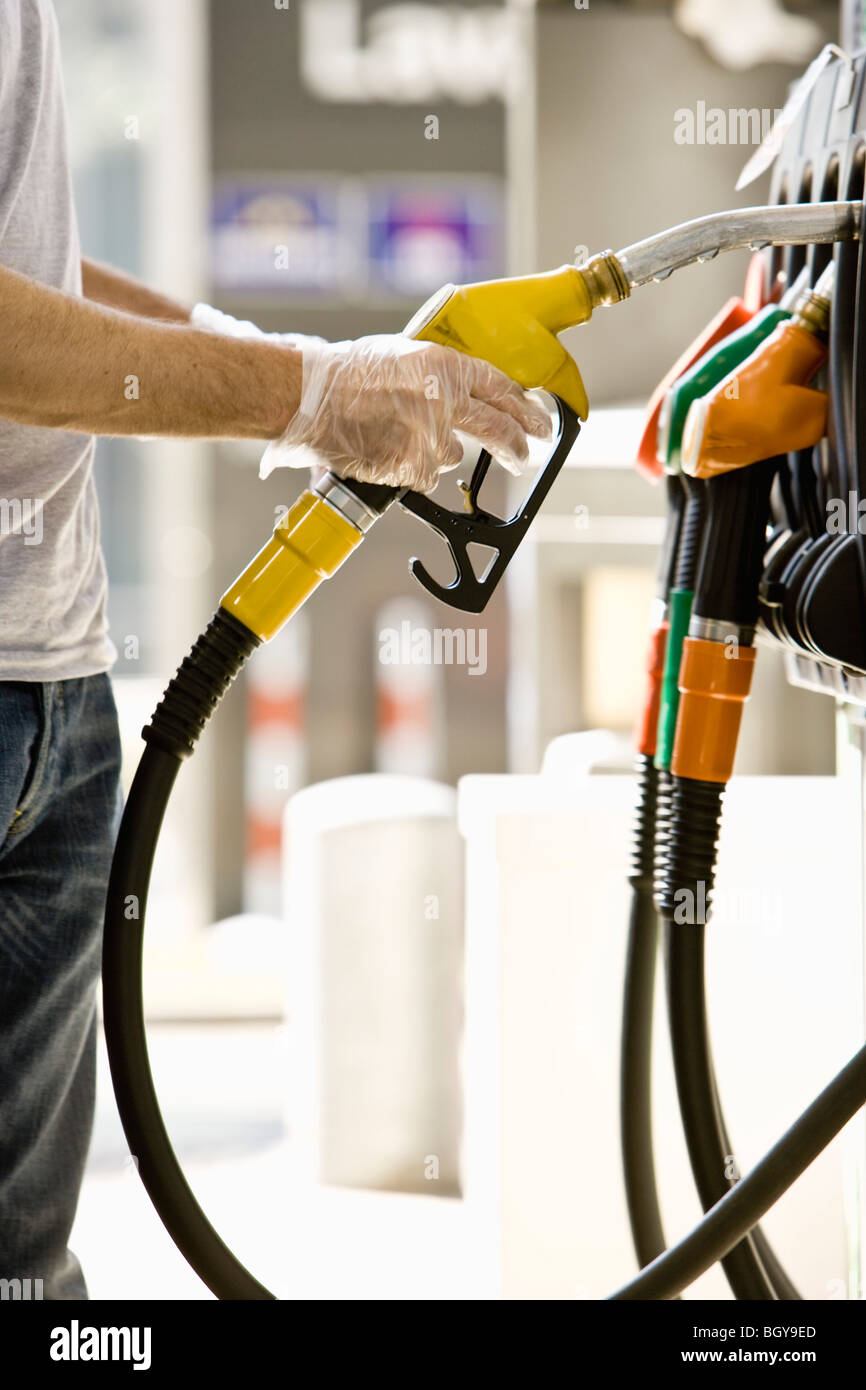 Man at gas pump preparing to refuel vehicle Stock Photo