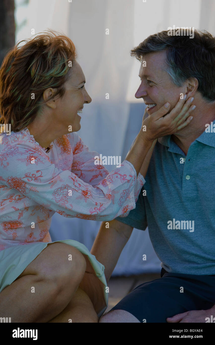 Mature couple gazing at each other, woman holding man's face Stock Photo