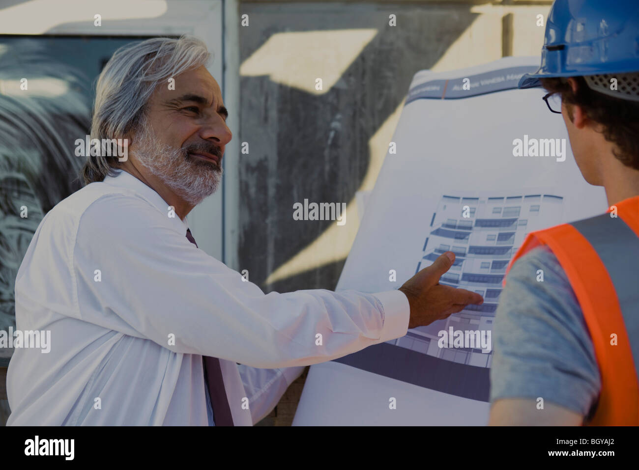 Architect explaining details of blueprint to construction worker Stock ...