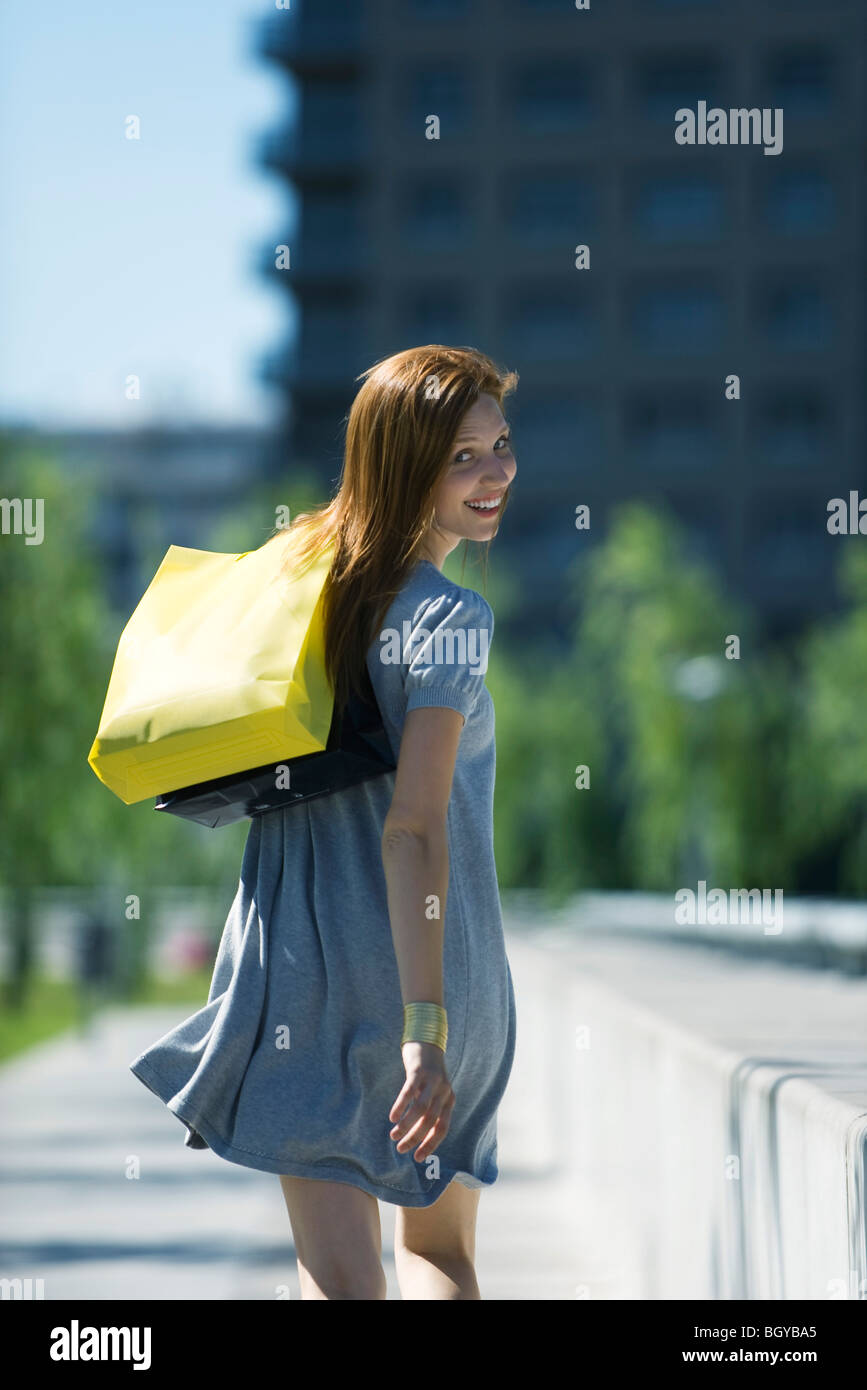 Woman carrying shopping bags over shoulder hires stock photography and