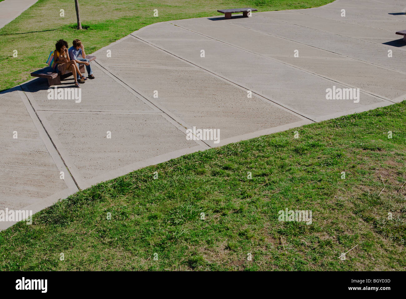Young couple sitting on park bench, high angle view Stock Photo