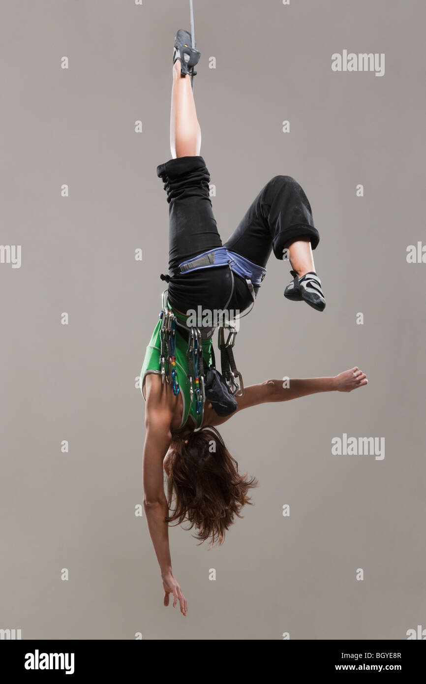 Female Climber hanging upside down Stock Photo