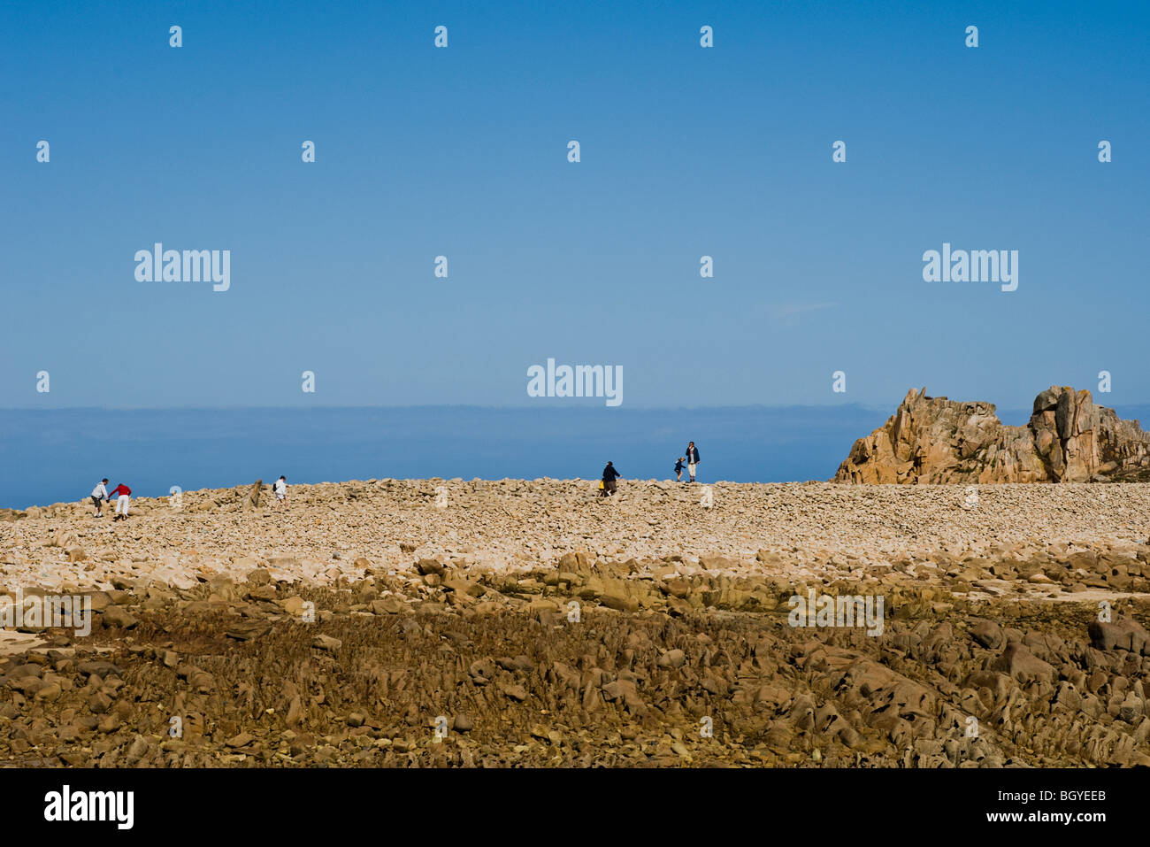 Tourists exploring coastal rock formation Stock Photo