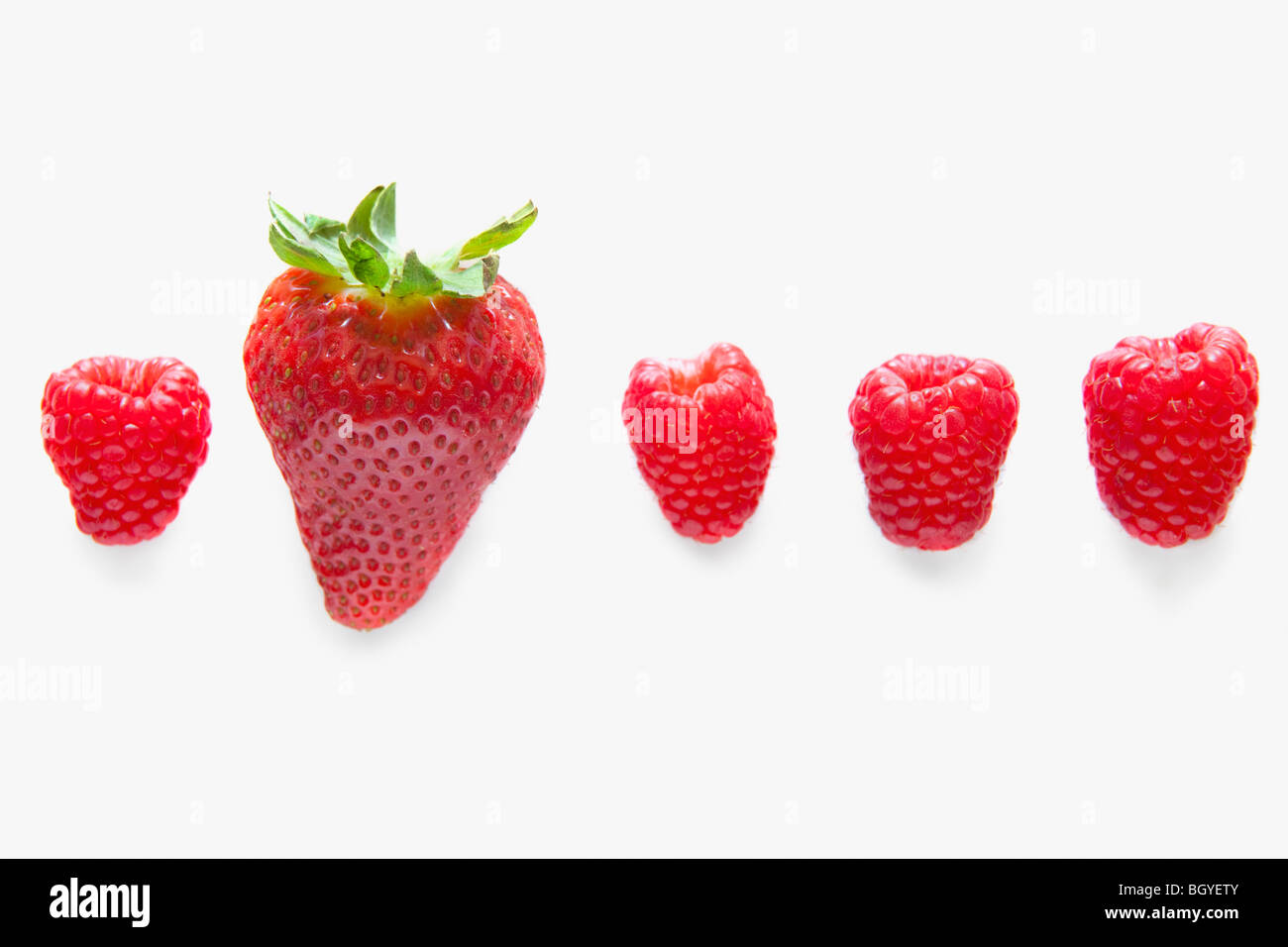Four raspberries and one strawberry Stock Photo