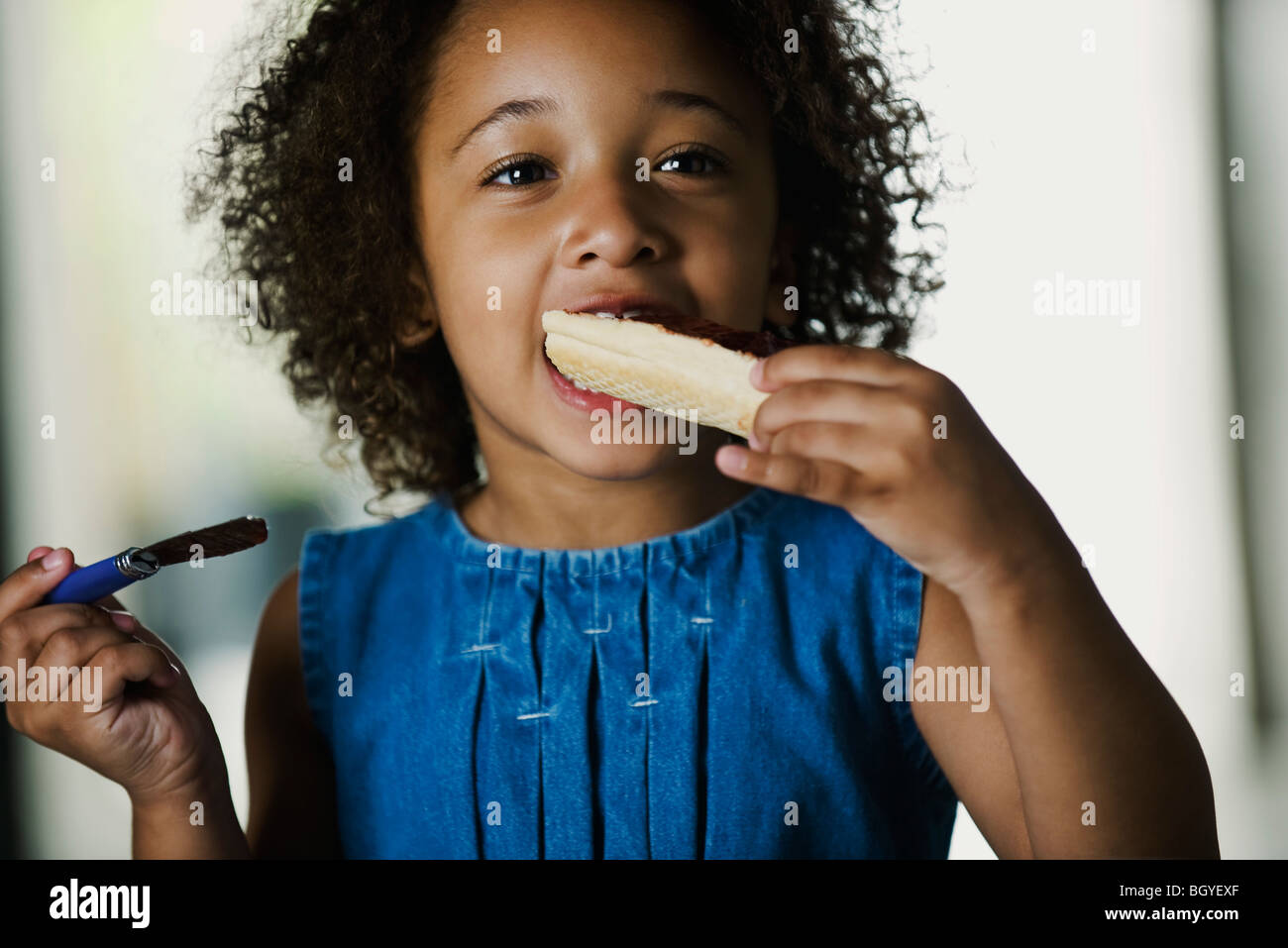Little girl eating snack Stock Photo Alamy