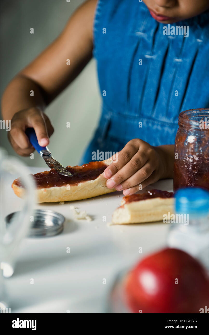 Little girl spreading jam on bread, cropped Stock Photo Alamy