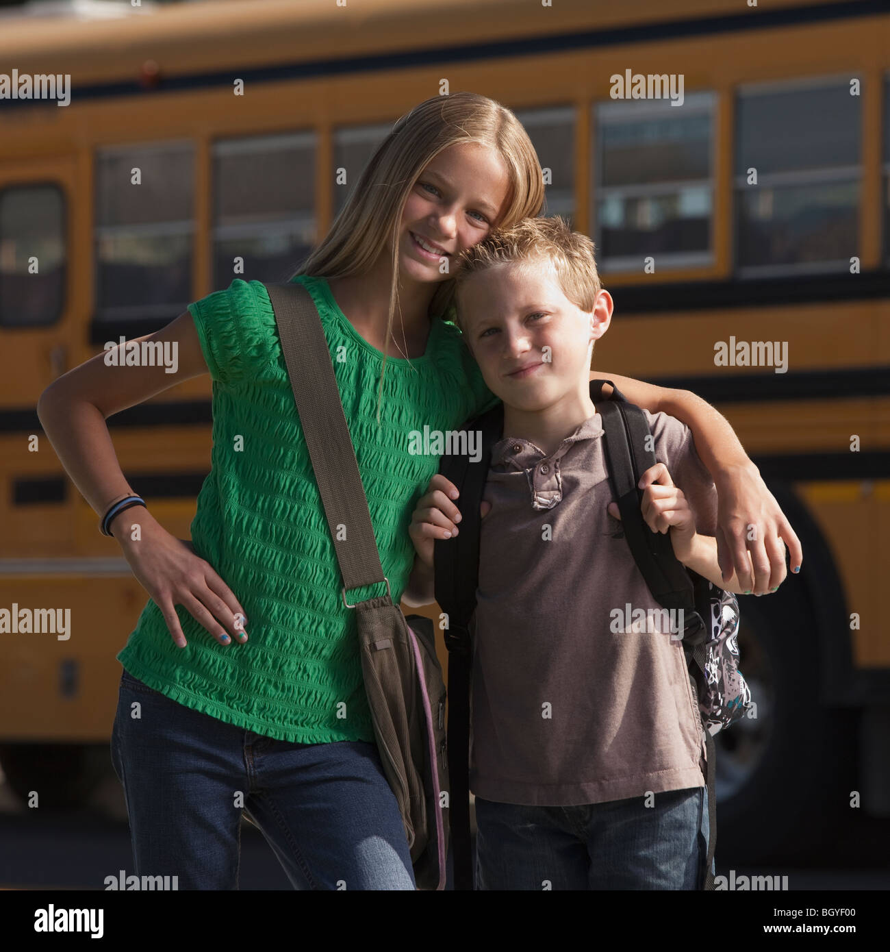 Friends in front of school bus Stock Photo