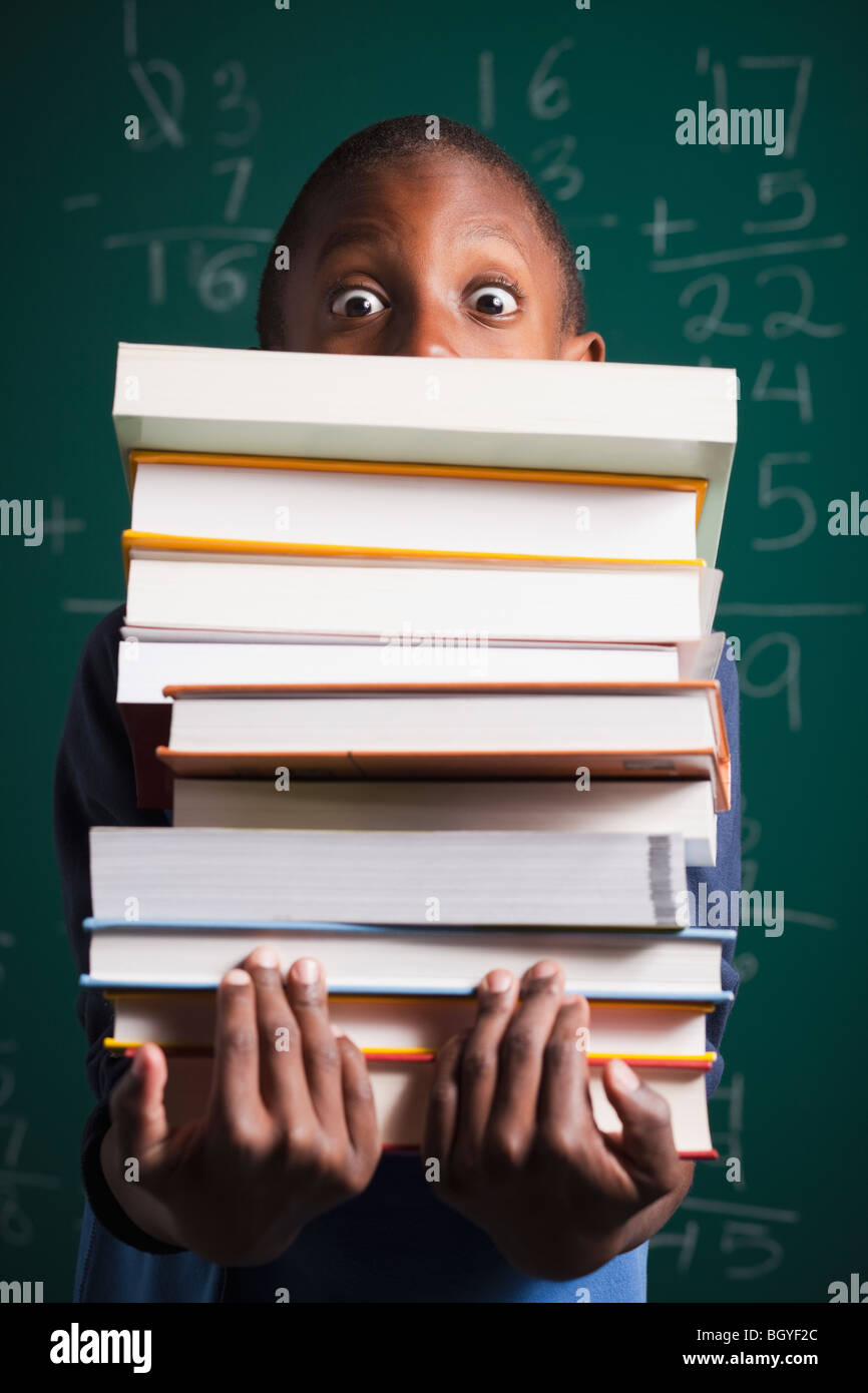Boy holding stack of books Stock Photo - Alamy