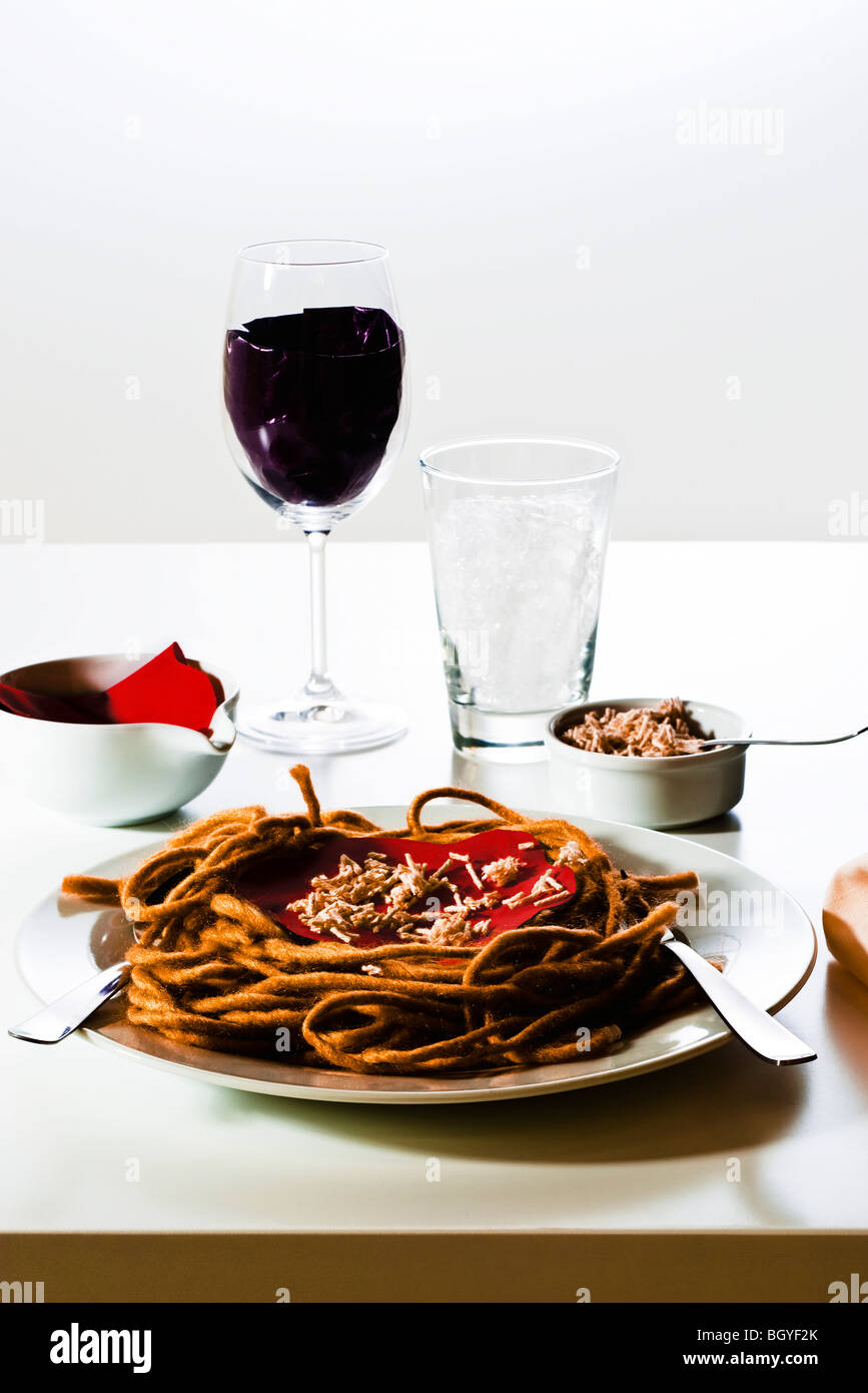 Food concept, fake spaghetti dinner and glass of wine constructed from yarn, fabric and other materials Stock Photo