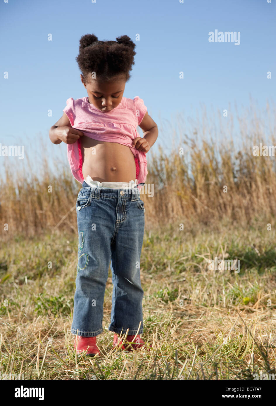 Young girl looking at her belly button Stock Photo