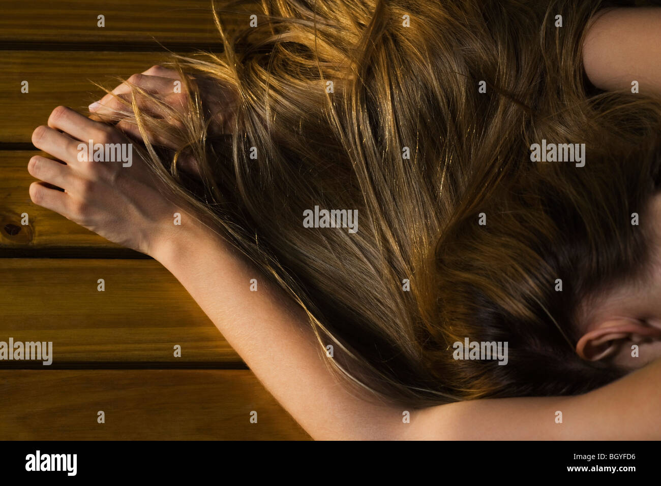 Woman lying face down on floor, long hair covering arm, cropped Stock Photo 27649698 Alamy