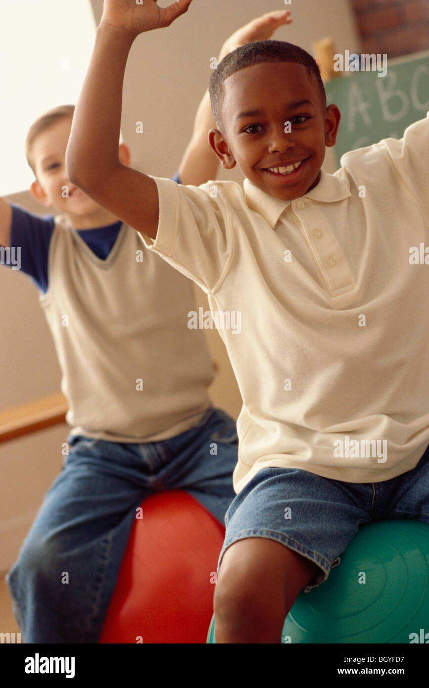 Students playing on exercise balls in classroom Stock Photo Alamy