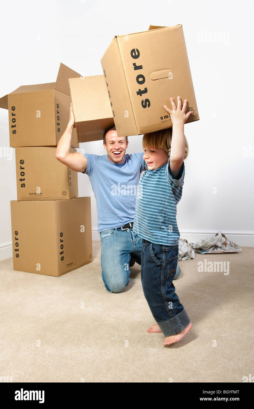Father and son playing with moving boxes Stock Photo