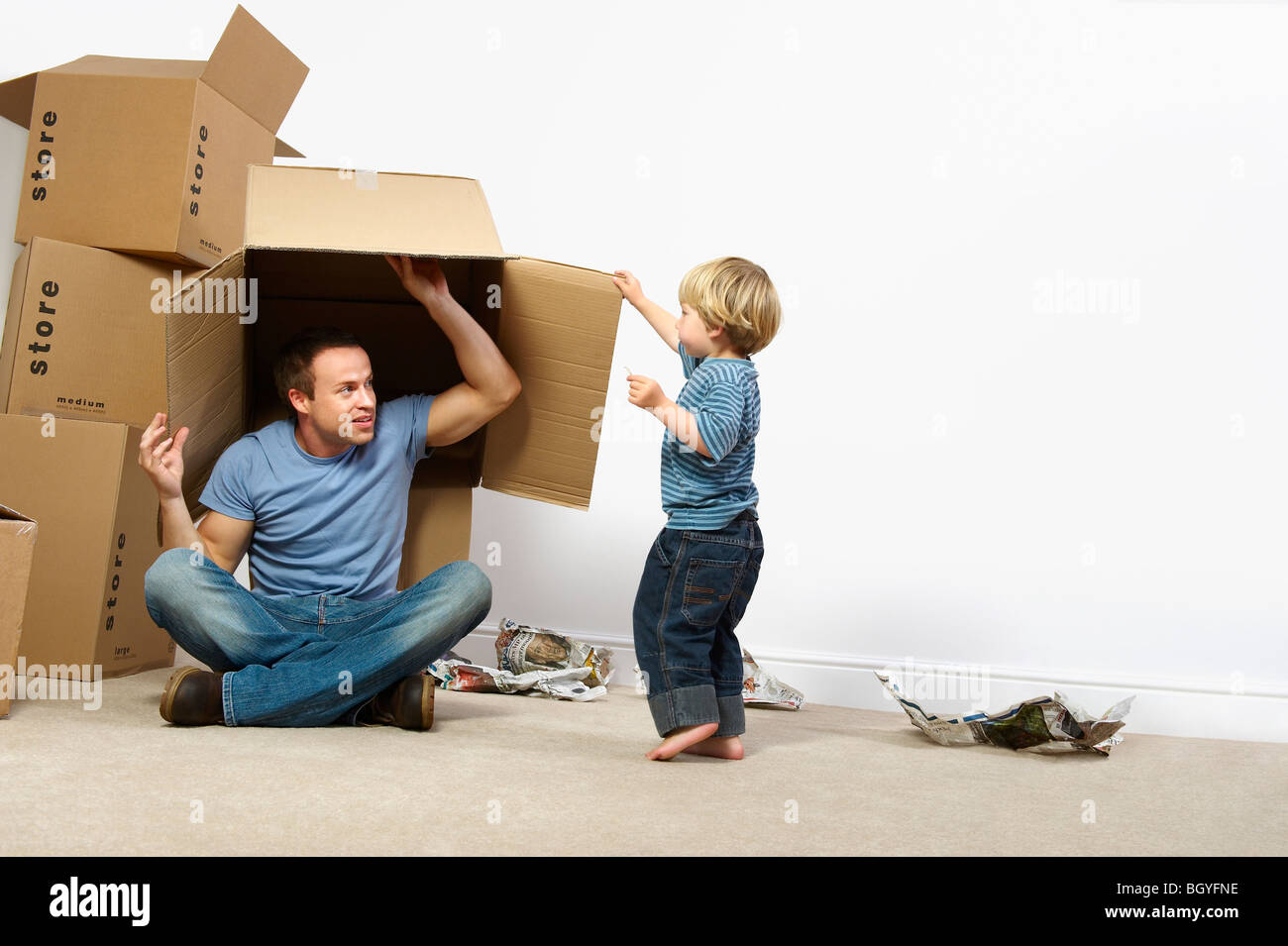 Father and son playing with moving boxes Stock Photo
