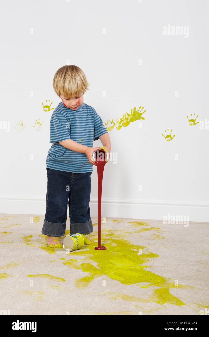 Toddler boy pouring paint onto carpet Stock Photo Alamy
