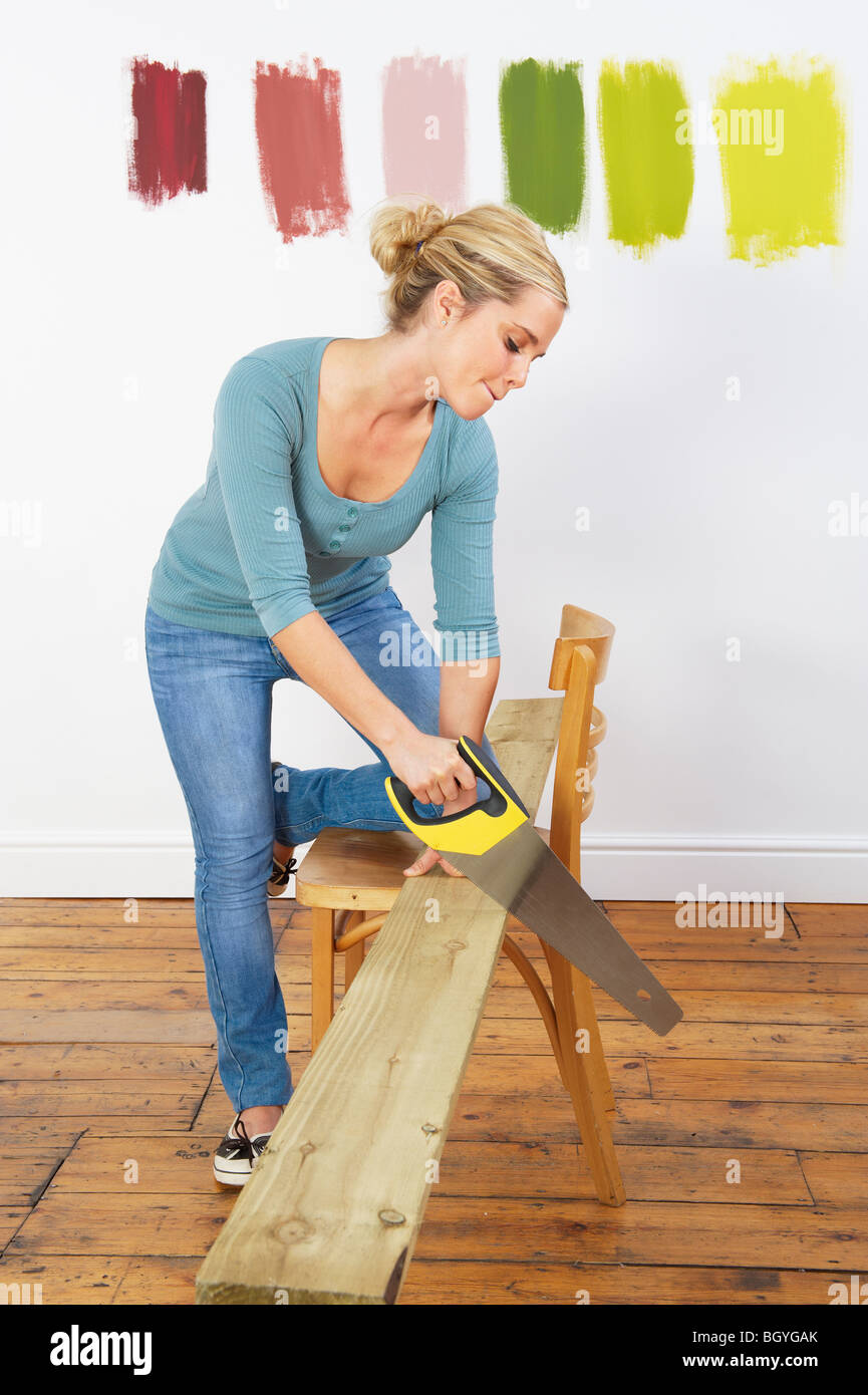 Woman sawing plank Stock Photo