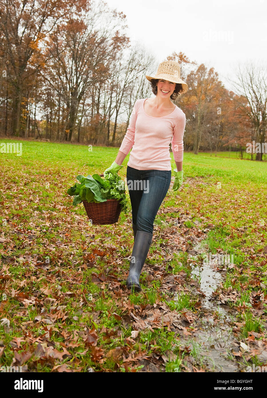 Woman walking with basket of vegetables Stock Photo - Alamy