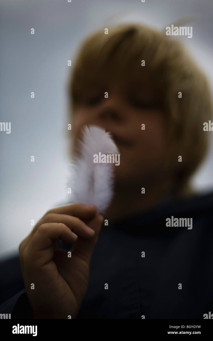 Boy holding white feather Stock Photo