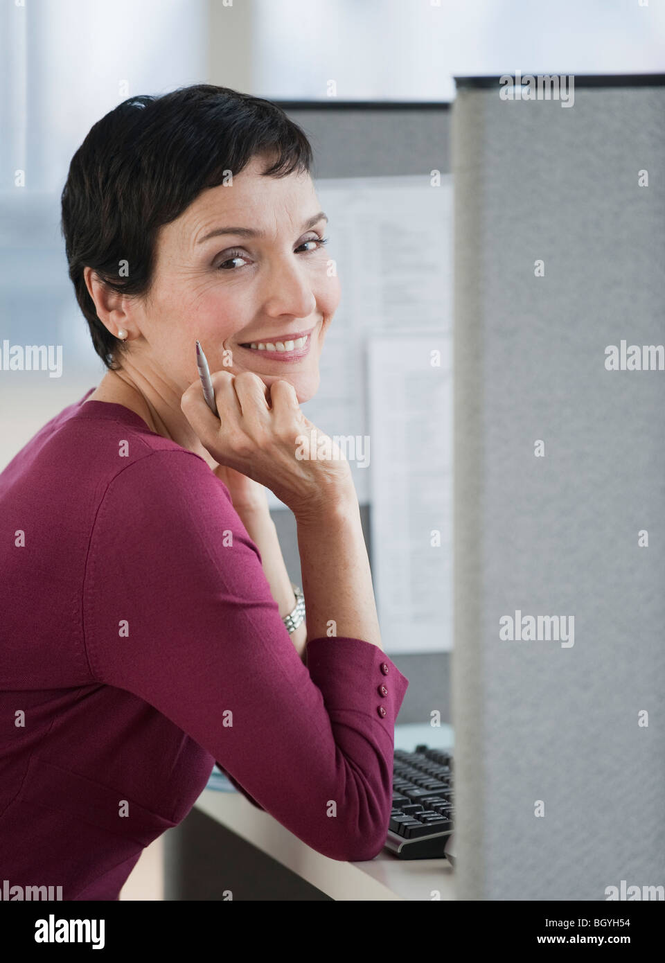 Businesswoman sitting at desk Stock Photo