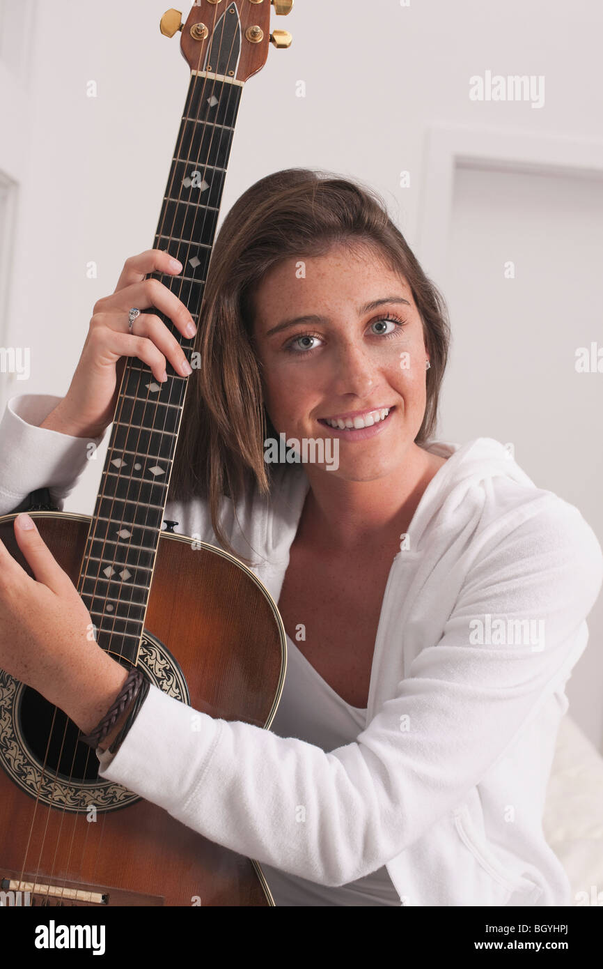 Young woman holding guitar Stock Photo - Alamy