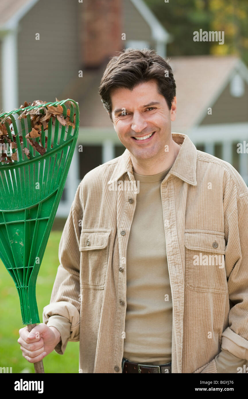 Man holding rake Stock Photo Alamy