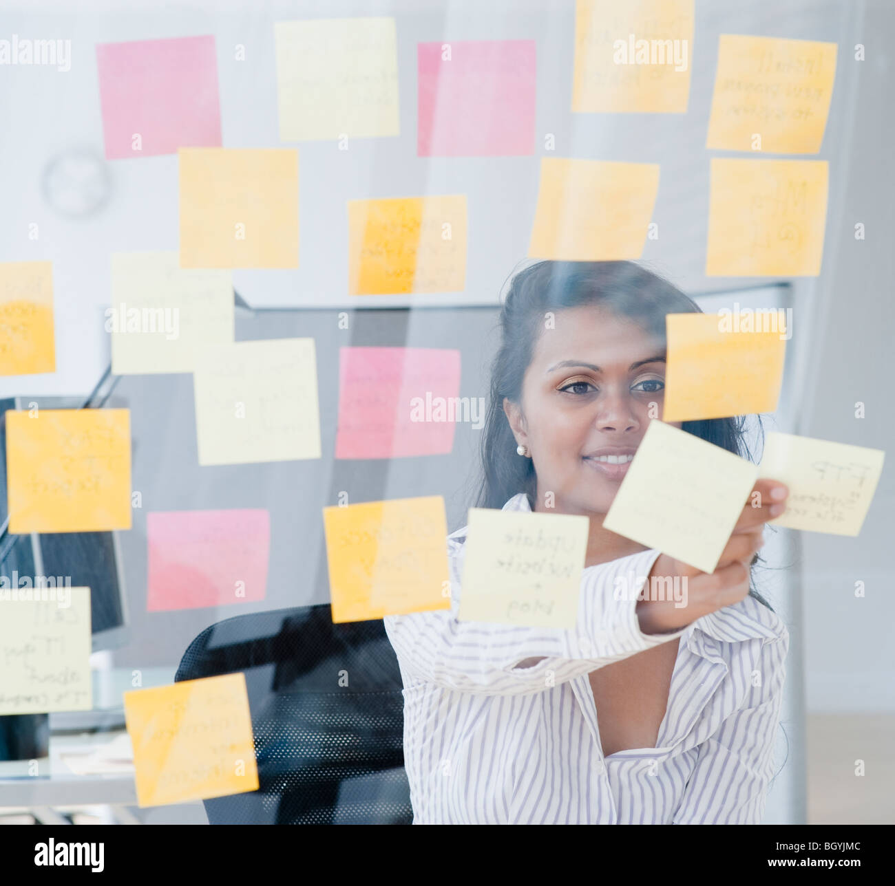 Woman looking at post-it notes Stock Photo