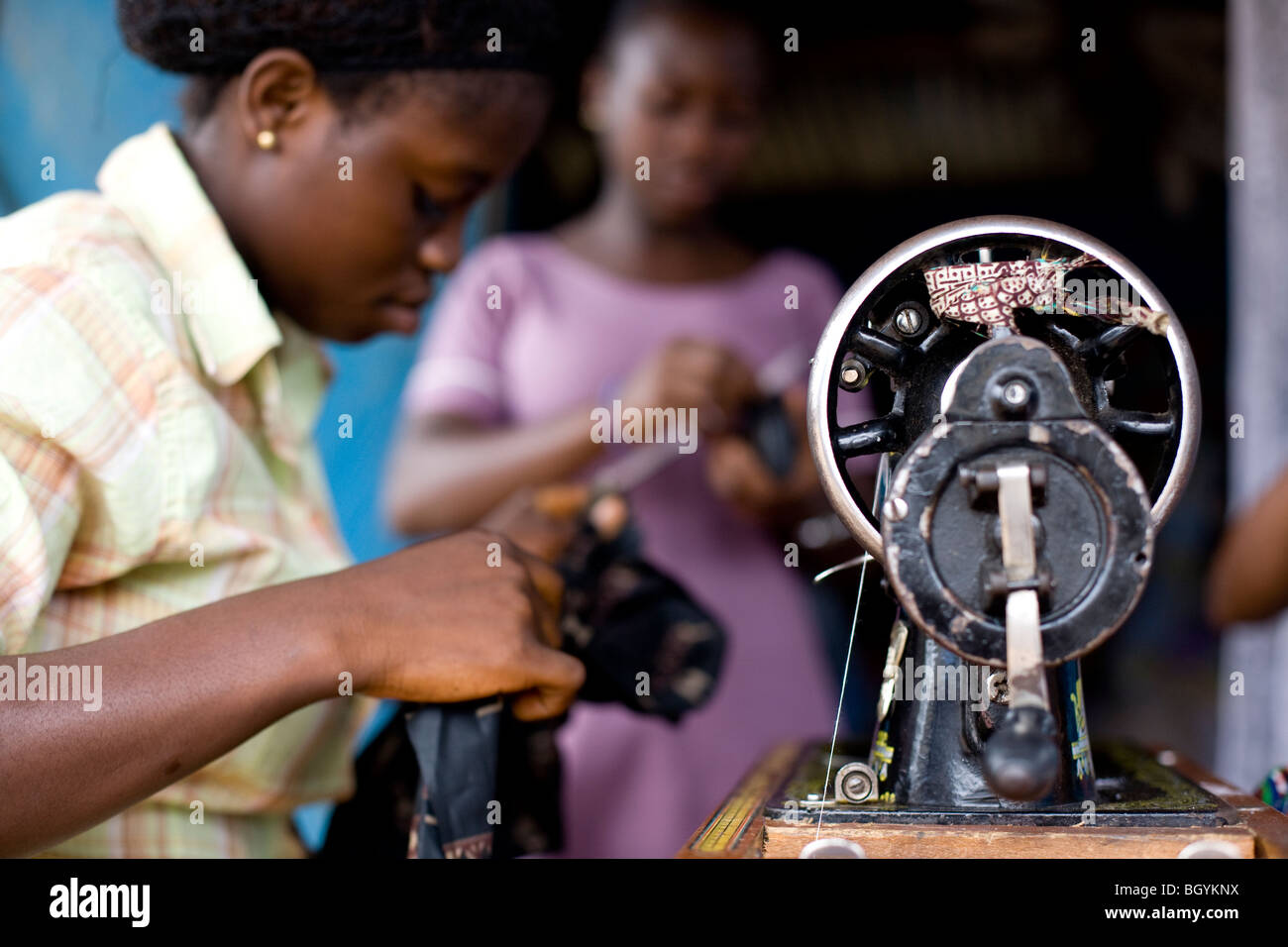 Young seamstress sewing clothes in her shop Stock Photo