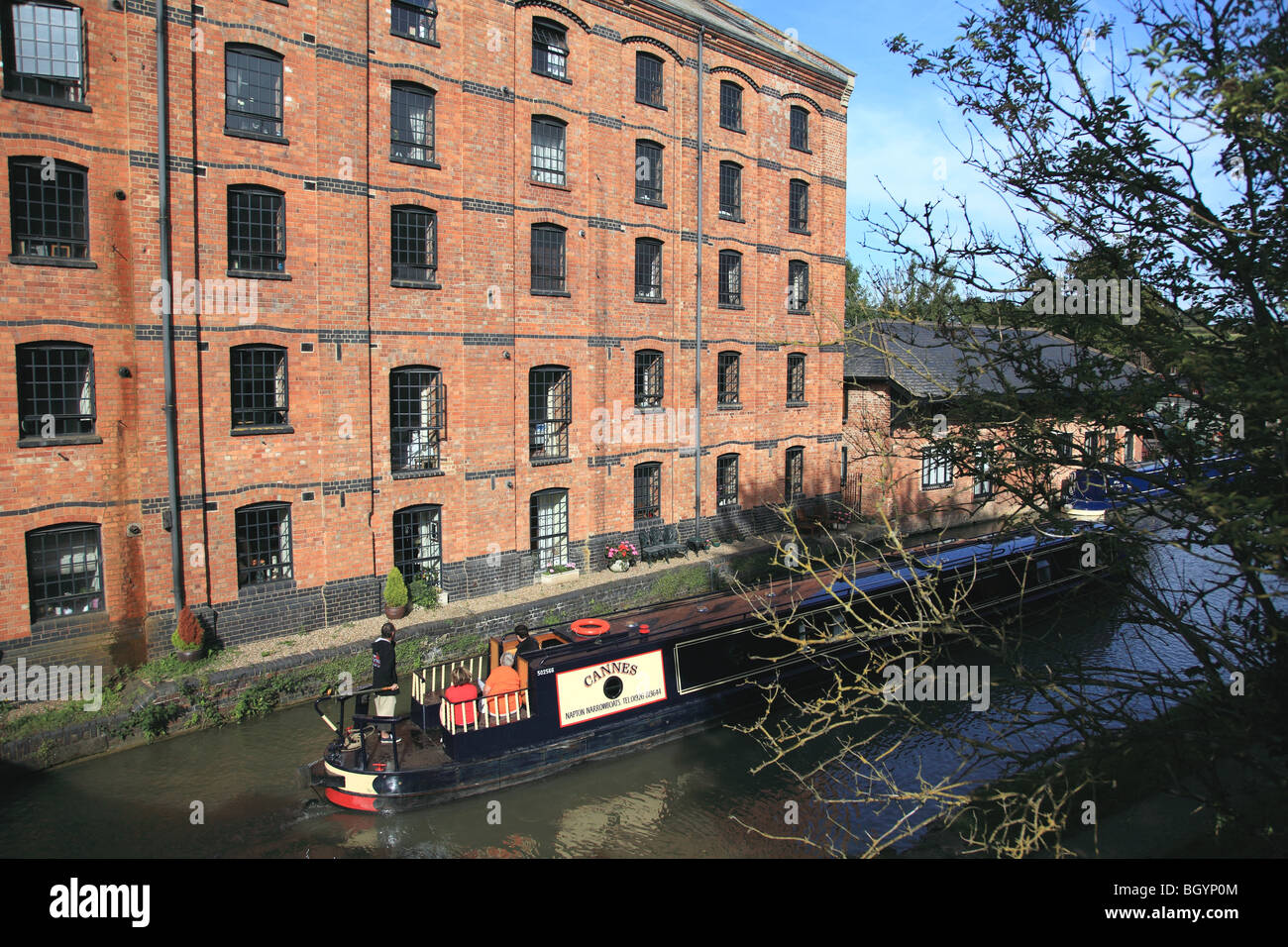 Narrowboat passing Blisworth Corn Mill, now converted into apartments