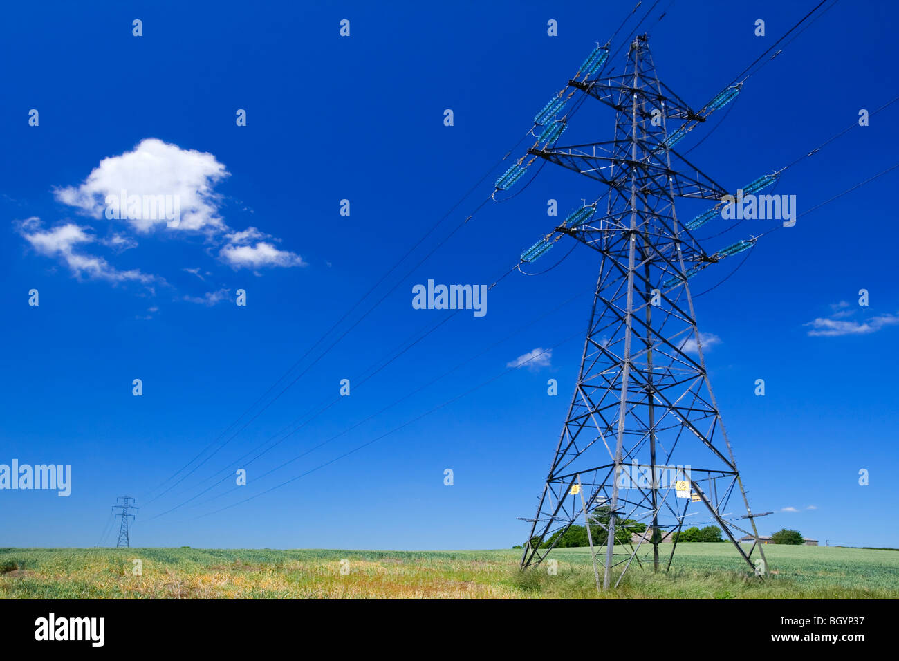 Electricity pylon with blue sky and small white clouds behind Stock ...