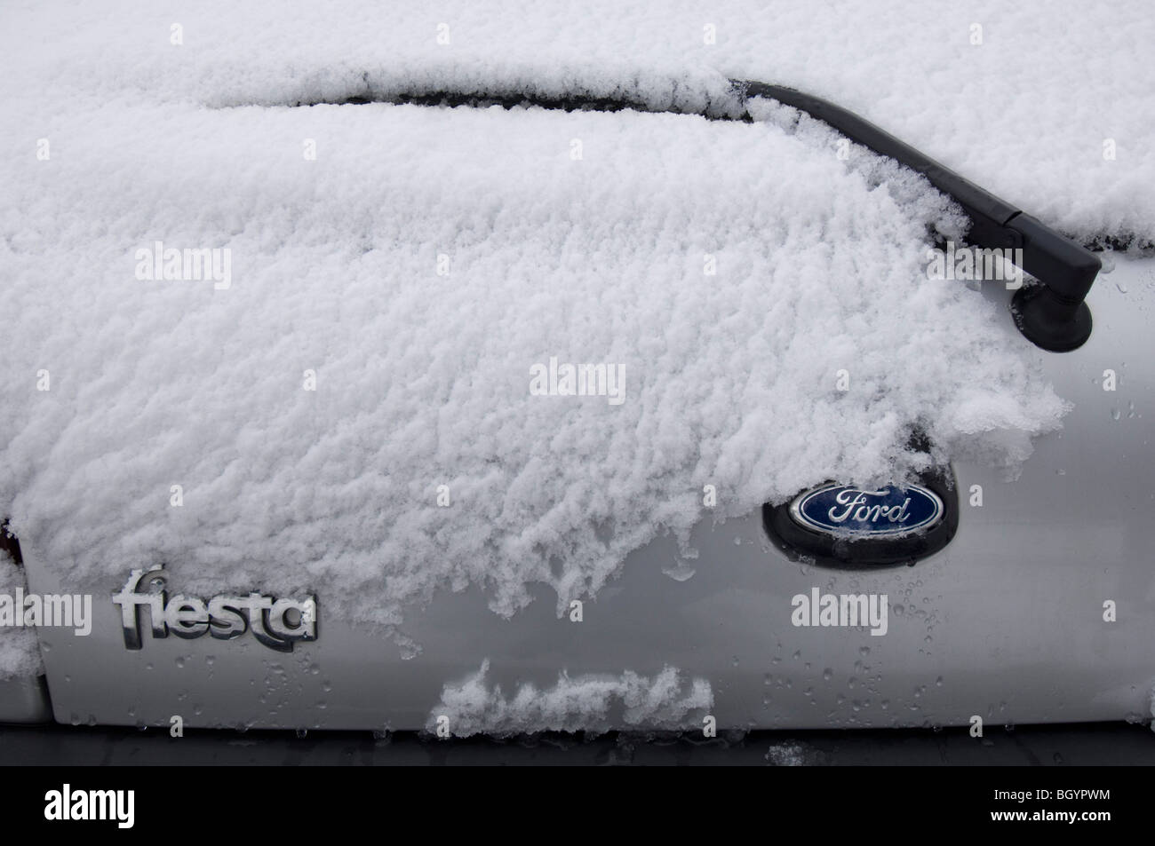 A snow covered Hatchback FORD FIESTA car showing the badges and rear
