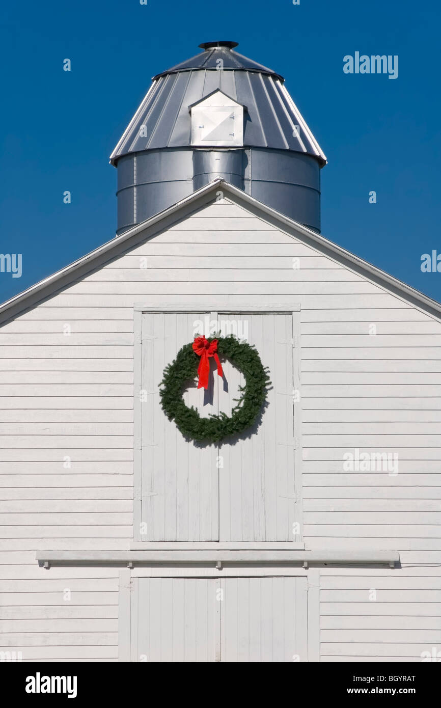 White barn with Christmas wreath on a sunny day. Stock Photo