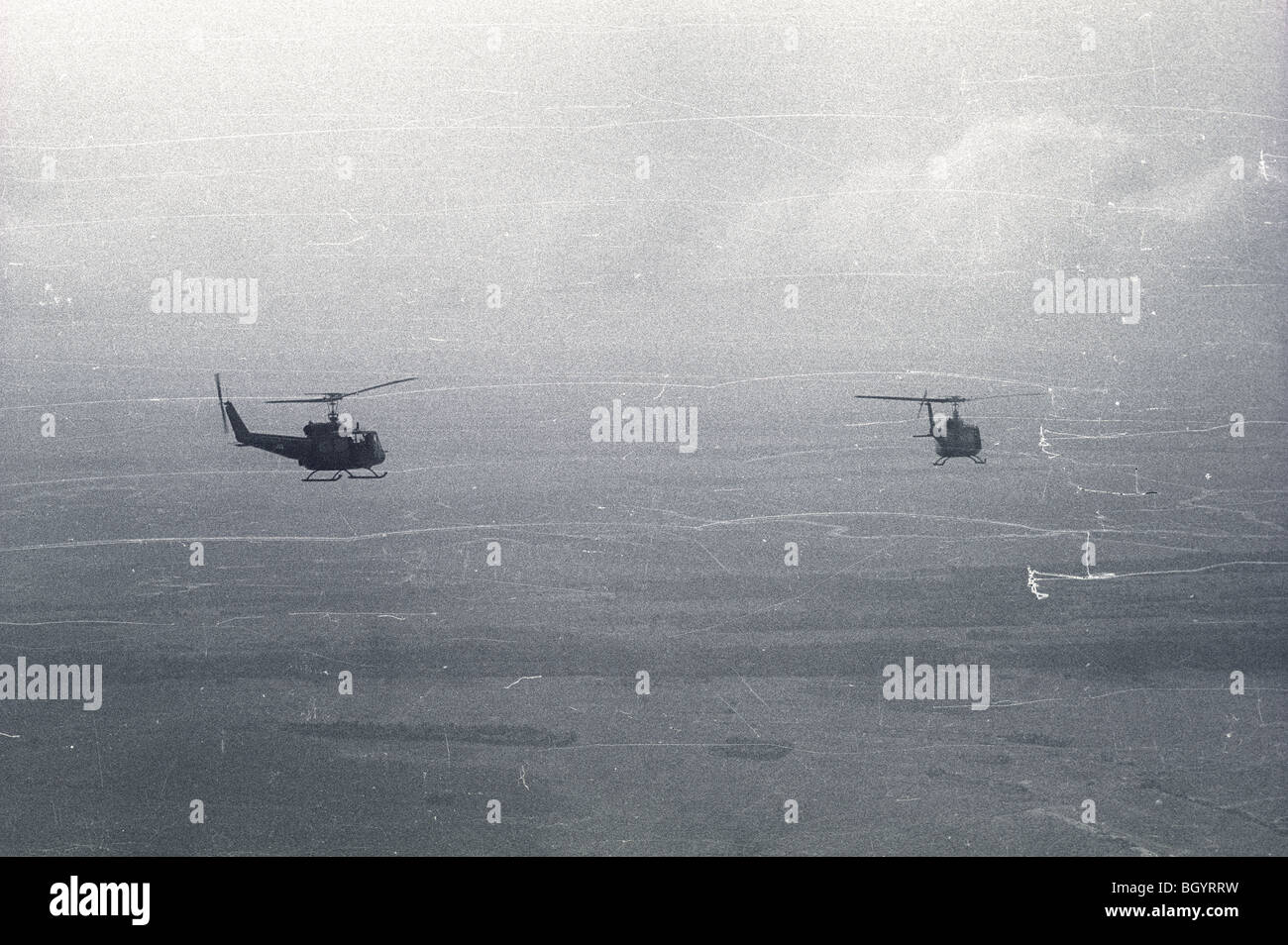 Two helicopters of the 121st AHC out of Soc Trang, Vietnam, fly in formation on a mission during the Vietnam War. Stock Photo