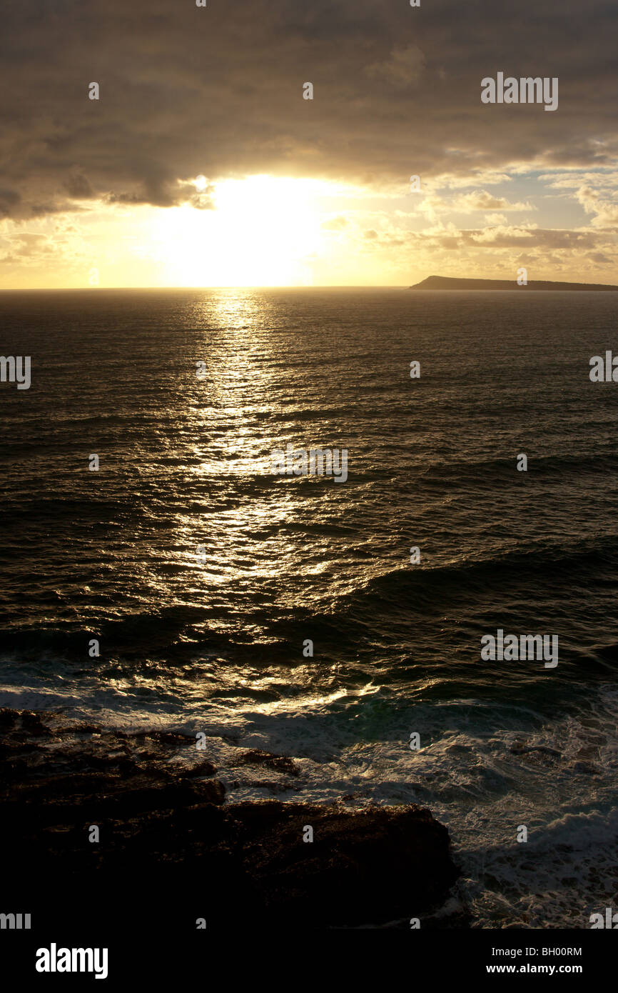 Sun setting over a stormy coastline Stock Photo - Alamy