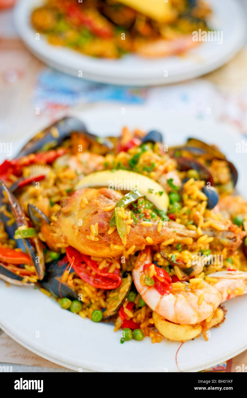 Beautiful and delicious paella in a white plate. Selective focus. Stock Photo