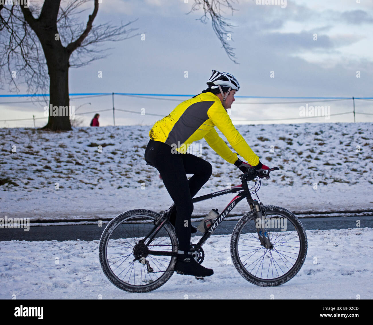 Cyclist with helmet safety gear riding bike on snow Stock Photo
