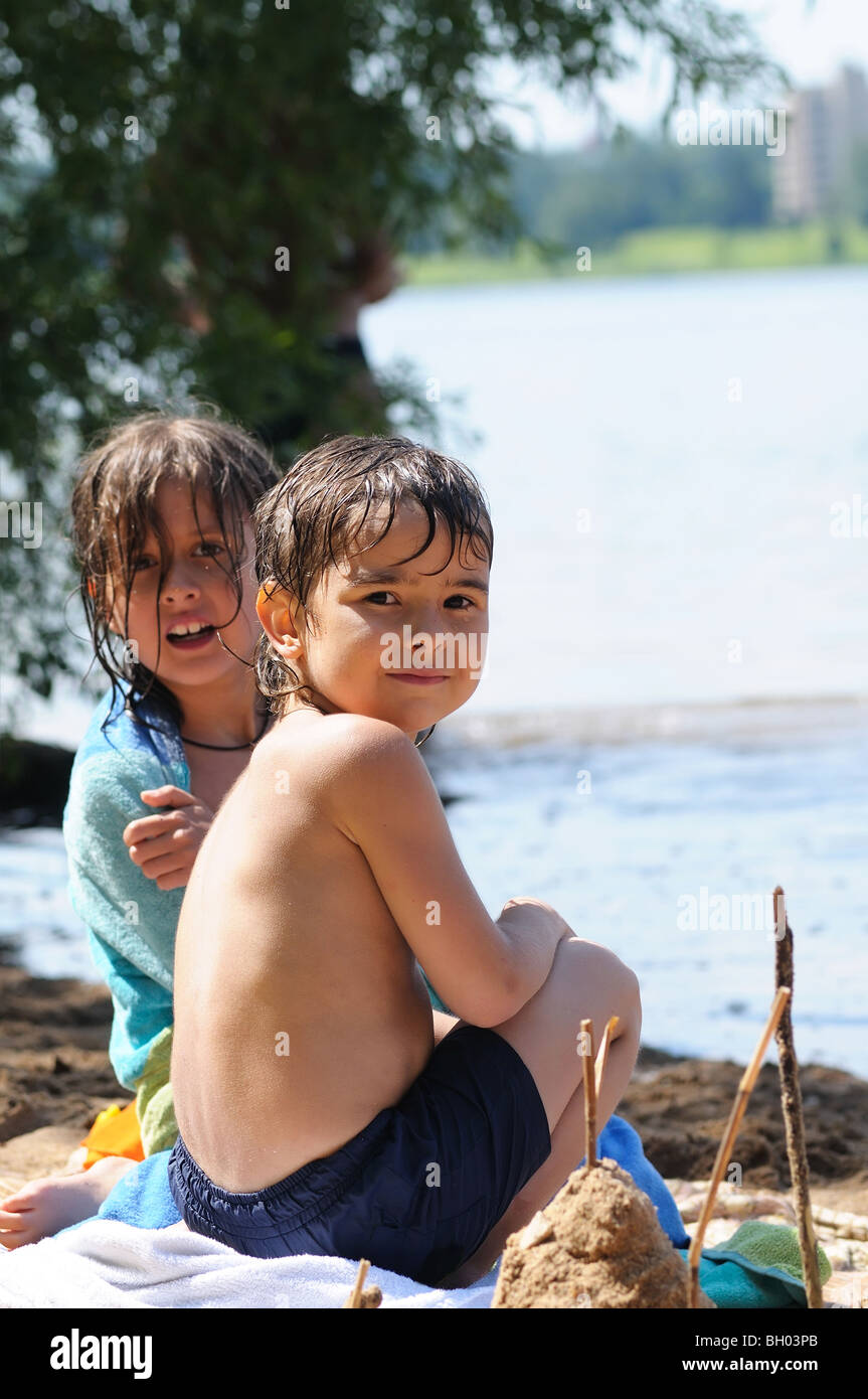 Two kids sitting on the beach Stock Photo