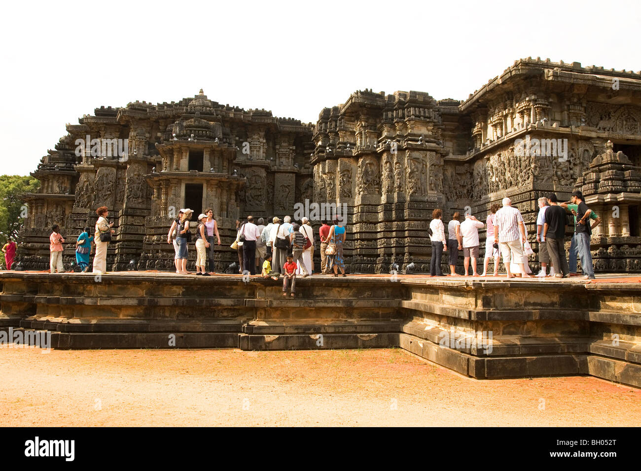 Tourists visit the Hoysaleshvara Temple at Halebid in Karnataka, India. Stock Photo