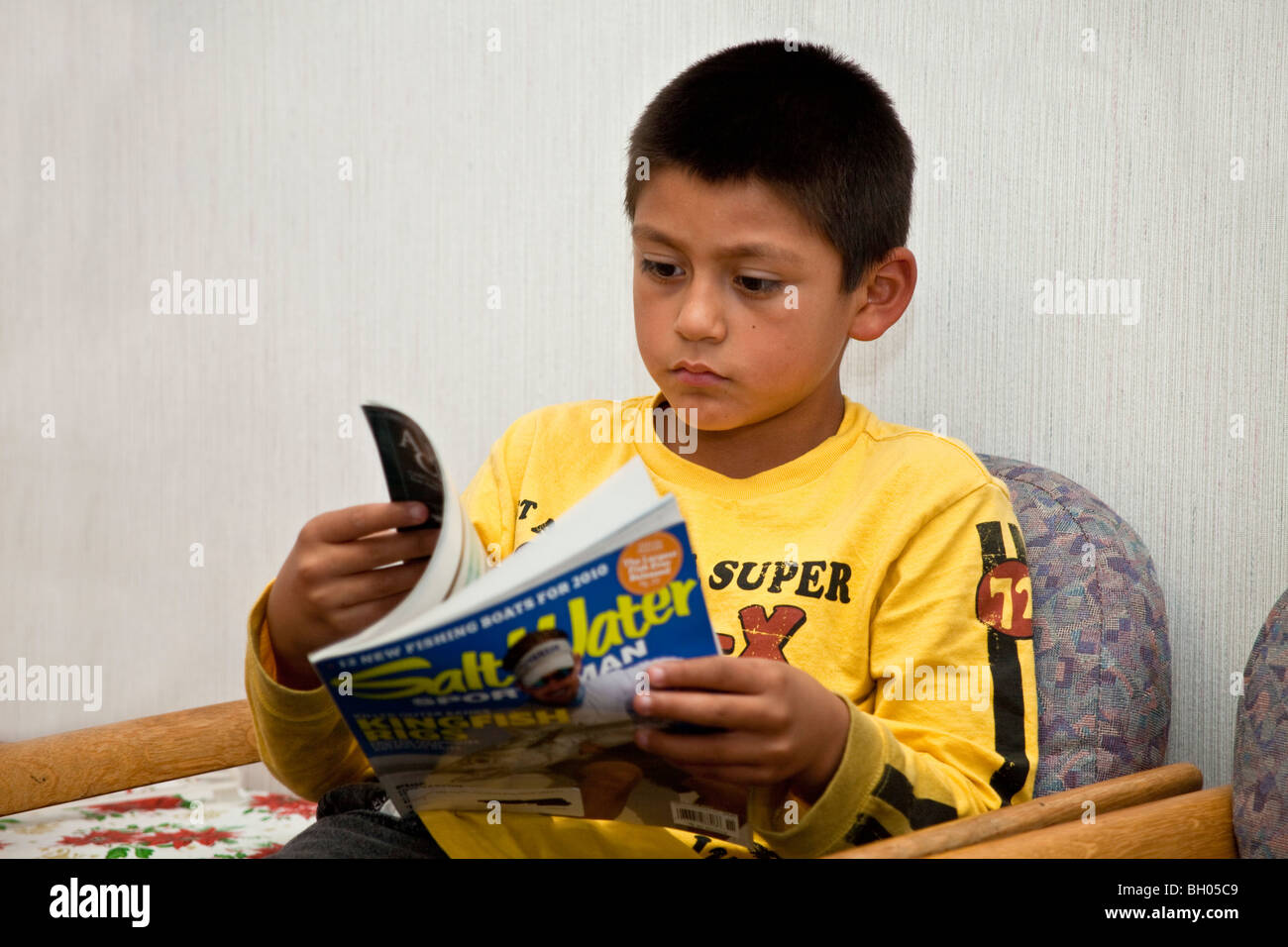 child children reading multi racial diversity racially diverse multicultural cultural Hispanic boy waiting for his appointment with the doctor. MR Stock Photo