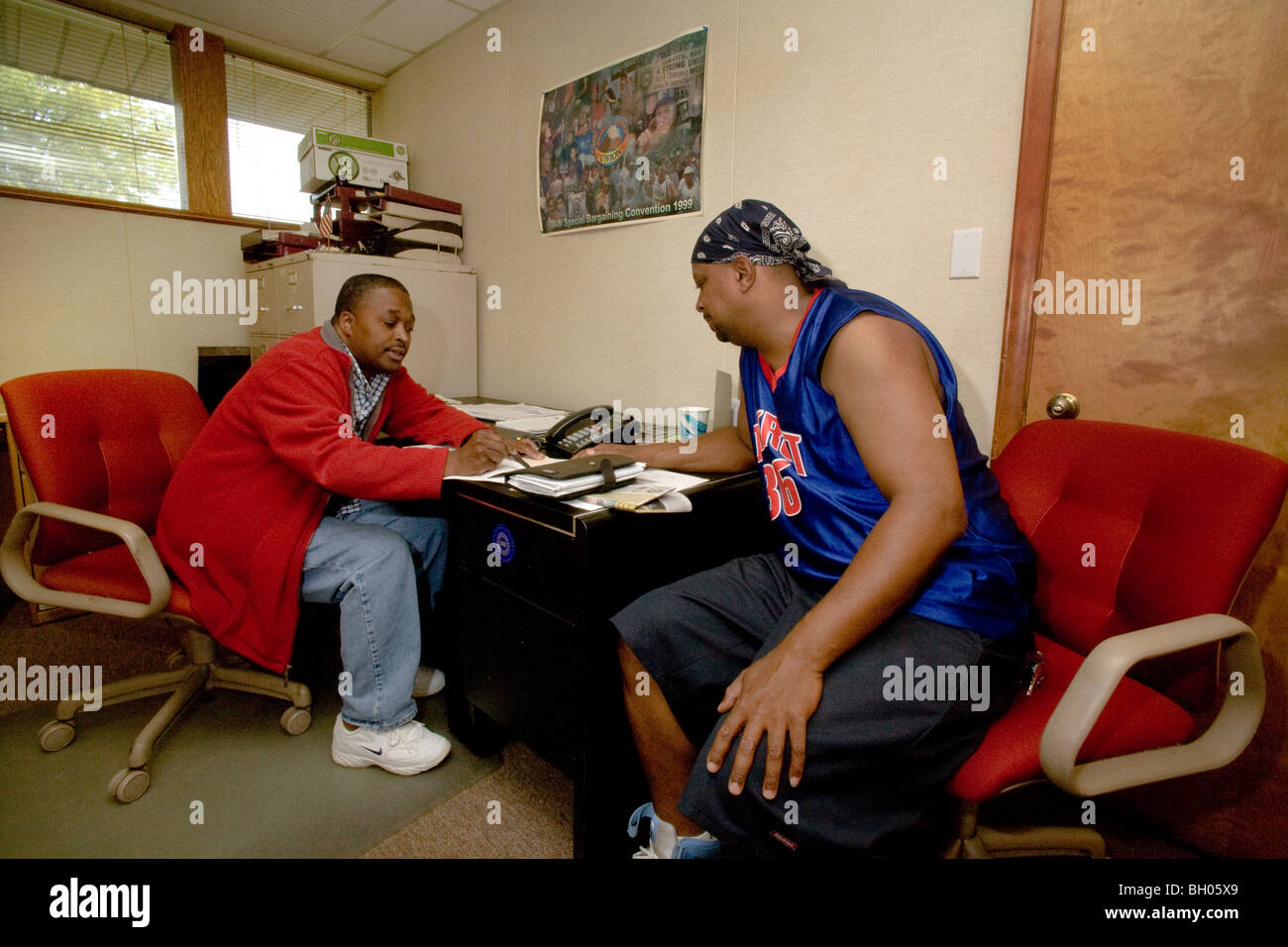 A United Auto Workers labor union volunteer peer counselor assists an unemployed member at a union local in Warren, Michigan. Stock Photo