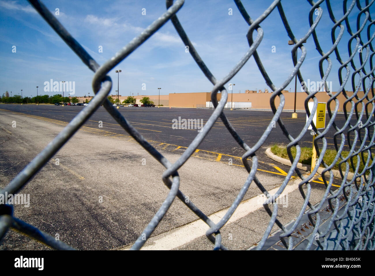 A chain link fence guards the empty parking lot of a idle automotive assembly plant in Detroit, MI, during high unemployment Stock Photo