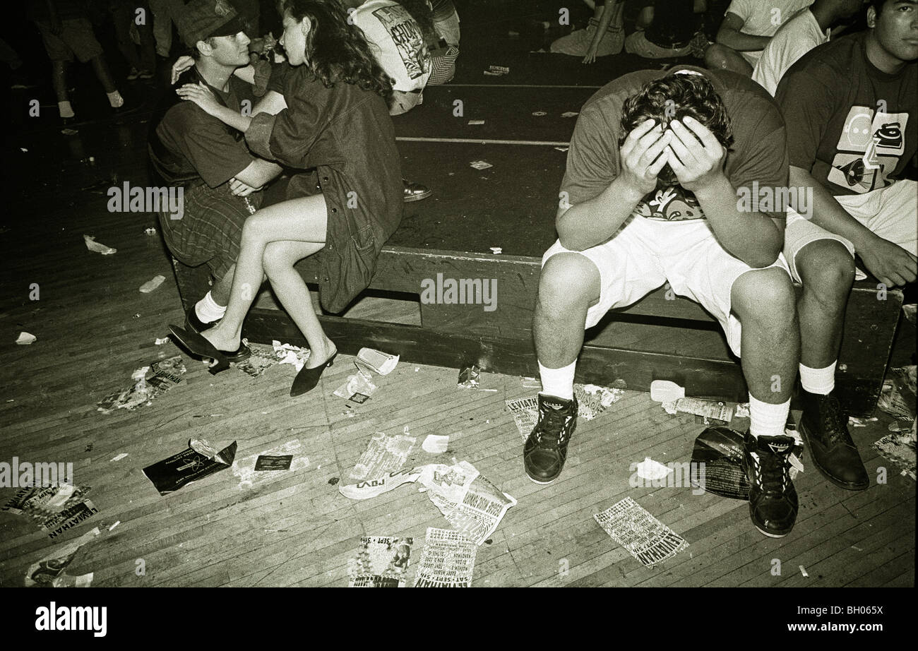 While a couple makes out a young male covers his head with his hands during the Technoflight rave at USC in Southern California Stock Photo