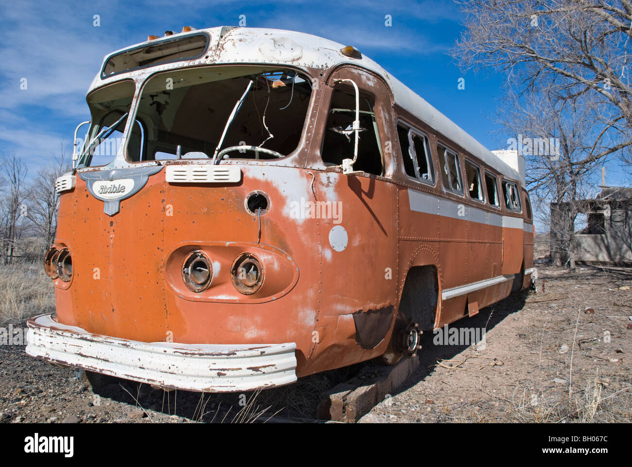 An old abandoned bus sits silently in a vacant lot outside the town of Carrizozo, New Mexico. Stock Photo