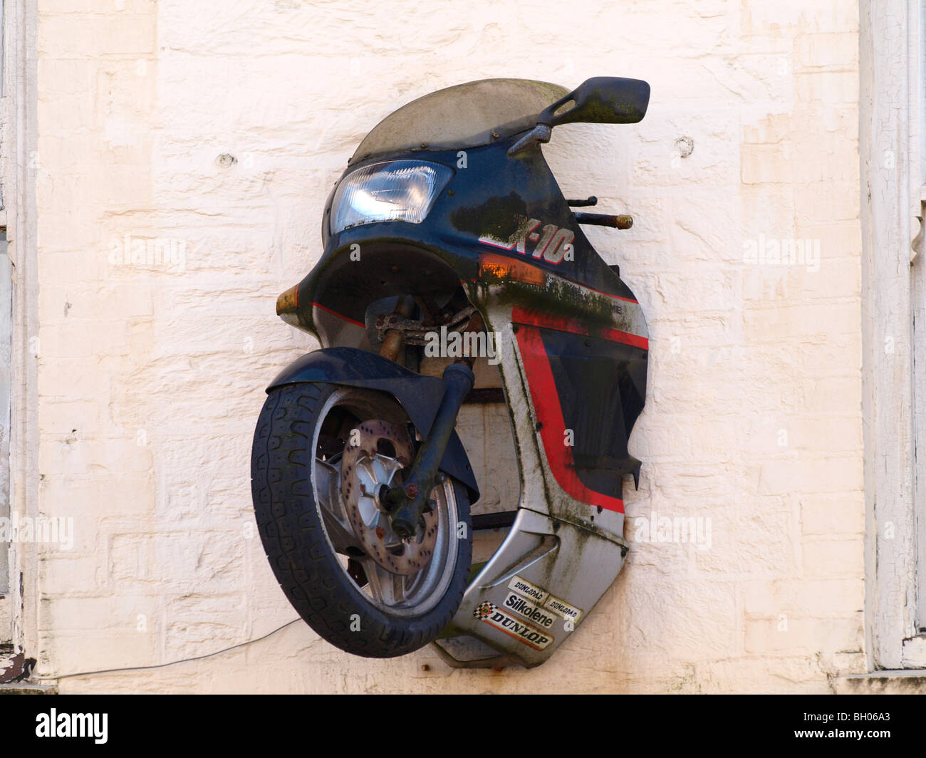 Front end of a motorbike sticking out of a wall of bike shop. Stock Photo