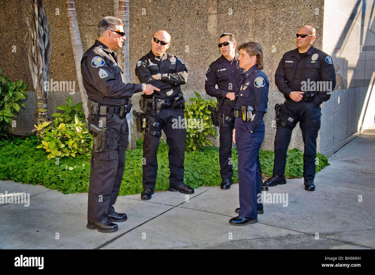 A female police commander speaks with members of her department's SWAT (Special Weapons And Tactics) team. Stock Photo