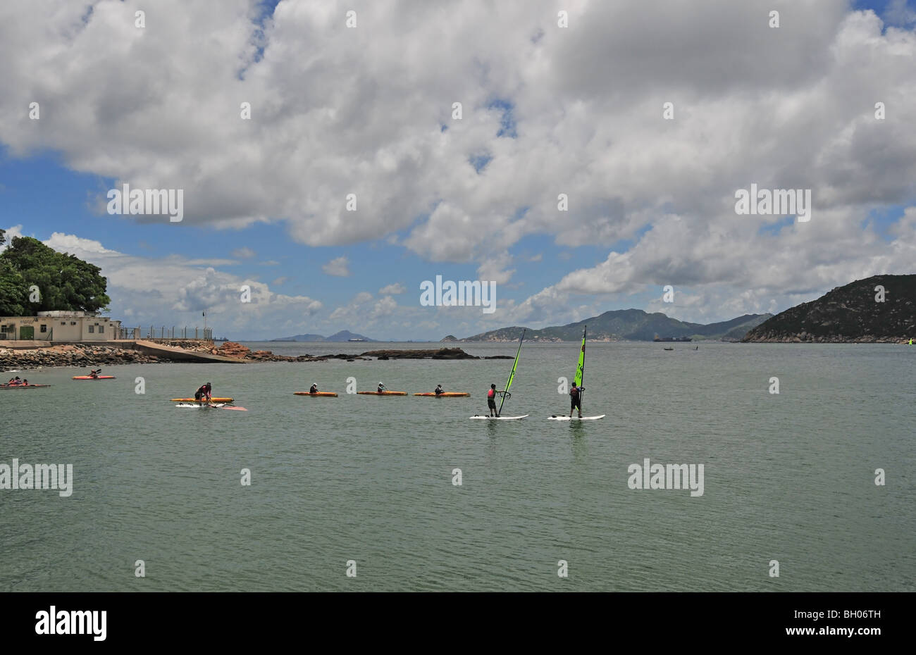 Wind surfers and canoeists on the calm waters of Stanley Bay, Stanley, Hong Kong, China Stock Photo