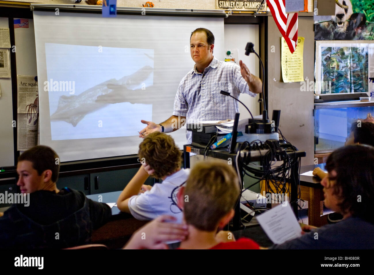 A middle school science teacher describes the day's project: dissection of a squid. Note television image of a squid on the proj Stock Photo