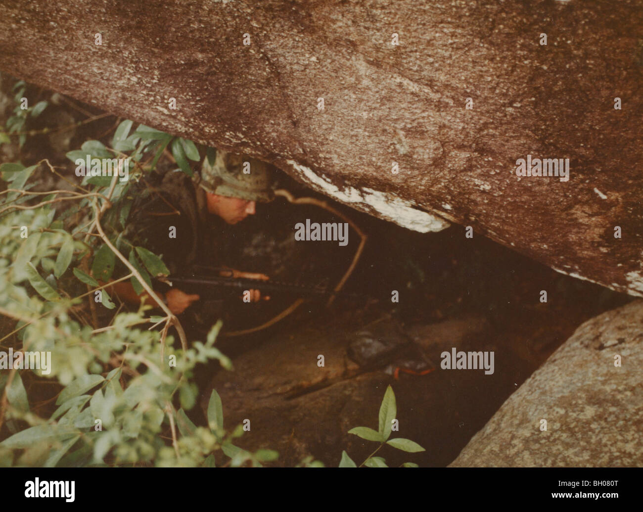 A squad leader, 7th Cavalry, 1st Cavalry Division checks a cave for a Viet Cong  a cache of Viet Cong arms. Stock Photo